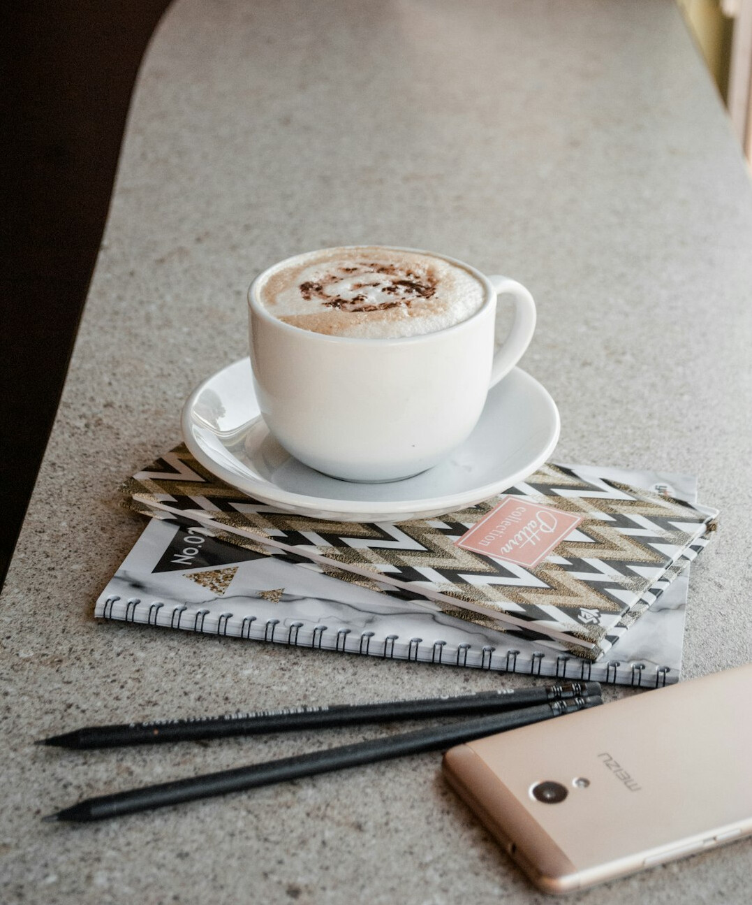 Open notebook with pen and coffee cup on a desk